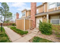 Inviting two-story home features a brick chimney, manicured bushes, and a private entrance way at 14343 E Dickinson Dr # E, Aurora, CO 80014