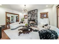 Bright living room featuring a modern fireplace, curved sofas, and contemporary lighting at 1440 Saint Paul St, Denver, CO 80206
