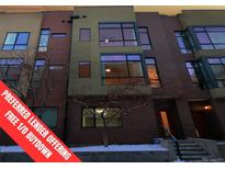 Attractive multi-story townhome showcasing a brick facade with large windows letting in natural light at 2345 Walnut St # 24, Denver, CO 80205