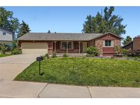 Charming single-story home featuring a well-manicured lawn and a classic brick and wood facade at 10247 W Arkansas Ave, Lakewood, CO 80232