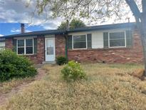 Quaint brick home featuring green shutters and a white front door at 2617 S Cimarron St, Aurora, CO 80014