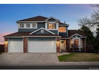 Charming two-story home featuring a three-car garage and manicured front lawn at 10103 Knoll Cir, Highlands Ranch, CO 80130