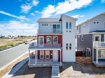 Two-story home with light-gray and red siding, and a double-balcony facade at 13616 E 103Rd Pl, Commerce City, CO 80022