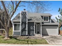 Charming two-story home with a gray exterior, manicured lawn, and attached two-car garage at 944 E Lily Ct, Highlands Ranch, CO 80126