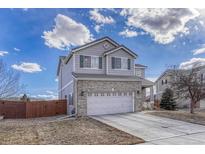 Charming two-story home with brick accents and a well-maintained front yard with a two car garage at 18668 E Vassar Dr, Aurora, CO 80013