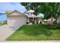 Charming two-story home with a well-manicured lawn and a cozy front porch at 13441 Cherry St, Thornton, CO 80241