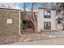 Inviting multi-level condo featuring brick and vinyl siding, complemented by mature trees and a cozy balcony at 3550 S Harlan St # 335, Denver, CO 80235