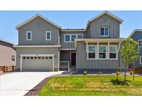 Charming two-story home featuring a gray exterior, well-maintained lawn, and attached two car garage at 1714 Morgan Dr, Erie, CO 80516