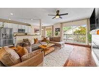 Inviting living room featuring a comfortable sectional sofa and a seamless transition to the kitchen area at 6813 W Yale Ave, Lakewood, CO 80227