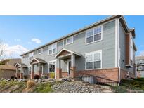 Charming townhouse with gray siding, brick accents, and a cozy covered entry at 8251 W 54Th Ave # 4, Arvada, CO 80002