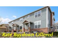 Charming townhome featuring blue siding, brick accents, and well-maintained landscaping at 8251 W 54Th Ave # 4, Arvada, CO 80002