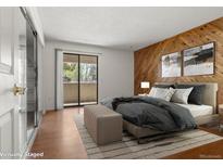 Bright bedroom featuring wood-paneled wall, balcony access, and soft neutral tones at 3662 S Granby Way # J05, Aurora, CO 80014