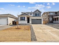 Charming two-story home with a grey exterior, gray garage door, and newly landscaped front yard at 9728 Cathay St, Commerce City, CO 80022