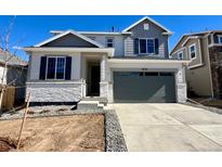 Charming two-story home featuring a modern gray color palette and well-manicured landscaping at 9728 Cathay St, Commerce City, CO 80022