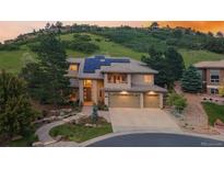 Beautiful stucco home with a three car garage, tile roof and solar panels nestled in a hillside community at 6338 Spotted Fawn Run, Littleton, CO 80125
