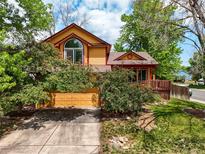 Charming two-story home featuring vibrant yellow siding, red trim, and mature landscaping at 3201 W 126Th Ave, Broomfield, CO 80020