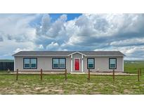 Charming single-story home featuring a bright red door and a well-maintained front yard at 6201 S Vanderhoof St, Bennett, CO 80102