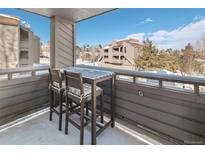 Cozy balcony features a dining table and chairs with views of the complex and surrounding landscape at 23694 Pondview Pl # B, Golden, CO 80401