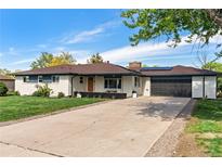 Ranch style home with painted white brick, a driveway and front lawn at 270 S Chase St, Lakewood, CO 80226