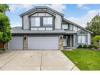 Charming two-story home featuring a three-car garage, stone accents, and manicured lawn at 8918 W 101St Ave, Broomfield, CO 80021