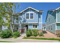 Charming two-story home with blue siding, well-maintained landscaping, and brick accents at 18947 E 57Th Pl, Denver, CO 80249