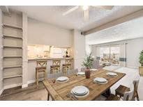 Inviting dining area features a rustic wood table, counter seating, and an open floor plan leading to the living room at 12143 Melody Dr # 104, Denver, CO 80234