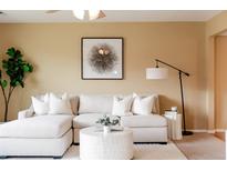 Bright living room featuring a comfortable, white sectional sofa and stylish decor at 654 S Xenon Ct, Lakewood, CO 80228