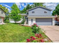 Charming two-story home featuring a well-manicured lawn and colorful flower beds at 6368 S Harlan Way, Littleton, CO 80123