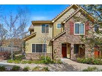 Charming home with a stone and siding exterior, manicured landscaping, and a welcoming front entrance at 10103 Bluffmont Ln, Lone Tree, CO 80124