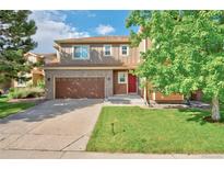 Charming two-story home features a stone-accented facade, manicured lawn, and a welcoming red front door at 3355 Willowrun Dr, Castle Rock, CO 80109