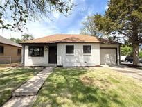 Charming single-story home features fresh paint, manicured lawn, and a one-car attached garage at 2895 Poplar St, Denver, CO 80207