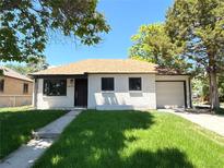 Charming single-story home with a well-manicured lawn, attached garage, and appealing neutral exterior paint at 2895 Poplar St, Denver, CO 80207