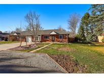 Traditional home featuring a well-maintained lawn and manicured garden at 6755 W 33Rd Ave, Wheat Ridge, CO 80033