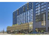 View of The Colo, a modern apartment building in a vibrant urban setting with sleek architecture and street-level retail at 1750 Wewatta St # 805, Denver, CO 80202
