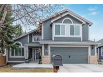 Charming gray two-story home with well-maintained landscaping and a two-car garage, offering curb appeal at 9208 W 100Th Pl, Broomfield, CO 80021