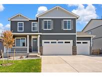 Beautiful two-story home with a three car garage, porch, and manicured front lawn at 1038 Scotts Peak Dr, Berthoud, CO 80513