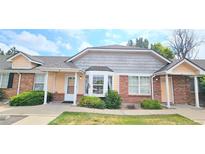Charming exterior of a townhome featuring a well-maintained lawn and classic architectural details at 1748 Eagle St # B, Aurora, CO 80011
