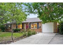 Charming brick home with a well-maintained front yard and a paved driveway leading to a two-car garage at 981 Ursula St, Aurora, CO 80011