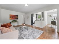 Bright living room with hardwood floors, modern decor, and an open view to the updated kitchen at 3344 W 33Rd Ave, Denver, CO 80211