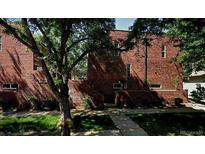 A view of the exterior of the brick home with ample green foliage and trees at 805 E 7Th Ave # 8, Denver, CO 80218