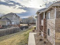 An apartment exterior shows a walkway and views of the yard and another home on a cloudy day at 8481 W Union Ave # 4-203, Littleton, CO 80123