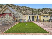Charming yellow home with a well-manicured lawn and lovely curb appeal at 230 Miner St, Idaho Springs, CO 80452