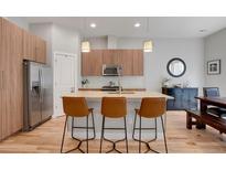 Stylish kitchen with wood cabinets, granite countertops, stainless steel appliances, and a breakfast bar with seating at 1921 Hooker St, Denver, CO 80204