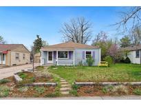 Charming single story home featuring a lovely front yard with a stone walkway and purple window shutters at 3278 S Lafayette St, Englewood, CO 80113