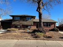 Traditional home boasts two-story construction and mature landscaping on a sunny day at 902 S Potomac Way, Aurora, CO 80012
