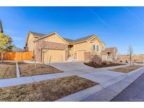 Brick and beige two-story home with attached garage and landscaped yard at 425 W 128Th Dr, Westminster, CO 80234