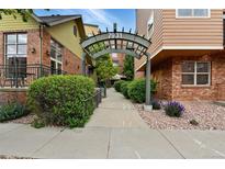 Inviting entrance to the building with lush landscaping and a covered walkway featuring the building number 7931 at 7931 W 55Th Ave # 105, Arvada, CO 80002