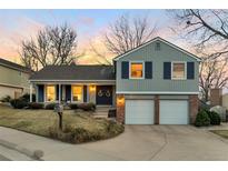 Charming two-story home featuring a two-car garage, front porch, and landscaped front yard during a colorful sunset at 6918 E Easter Pl, Centennial, CO 80112