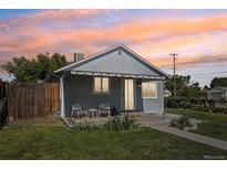 Charming single-story home with a covered front porch, green lawn, and blossoming plants adding curb appeal at 6691 Hooker St, Denver, CO 80221