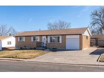 Charming brick home featuring an attached garage and a well-maintained front yard on a sunny day at 3288 W Tufts Ave, Englewood, CO 80110